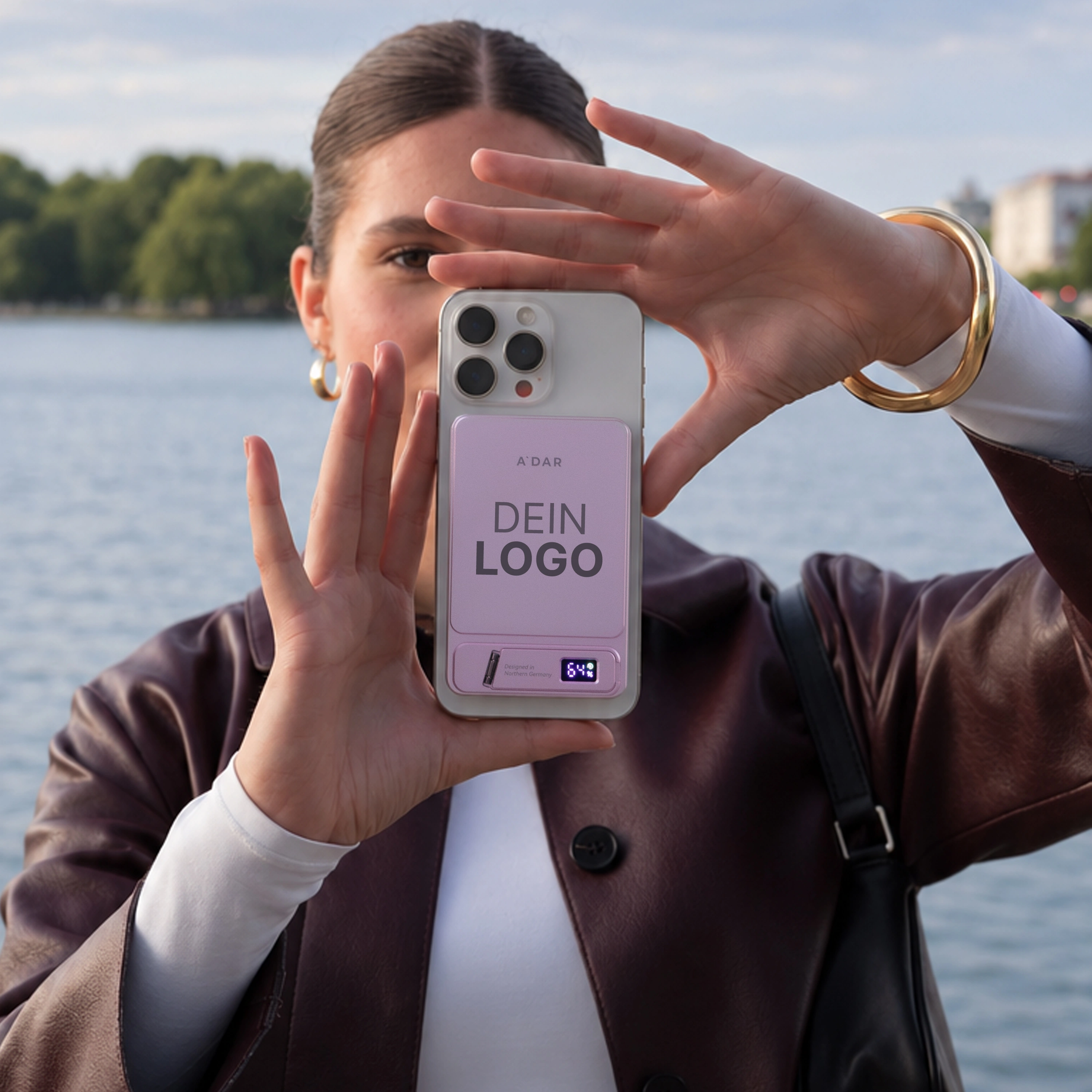 Person hält ein Smartphone mit magnetisch befestigter AdarCharge Powerbank in Pink